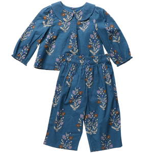 The Pink Chicken Baby Girls’ Dawson 2-Piece Set features a floral blue Peter Pan collar top and matching wide-leg botanical print pants.