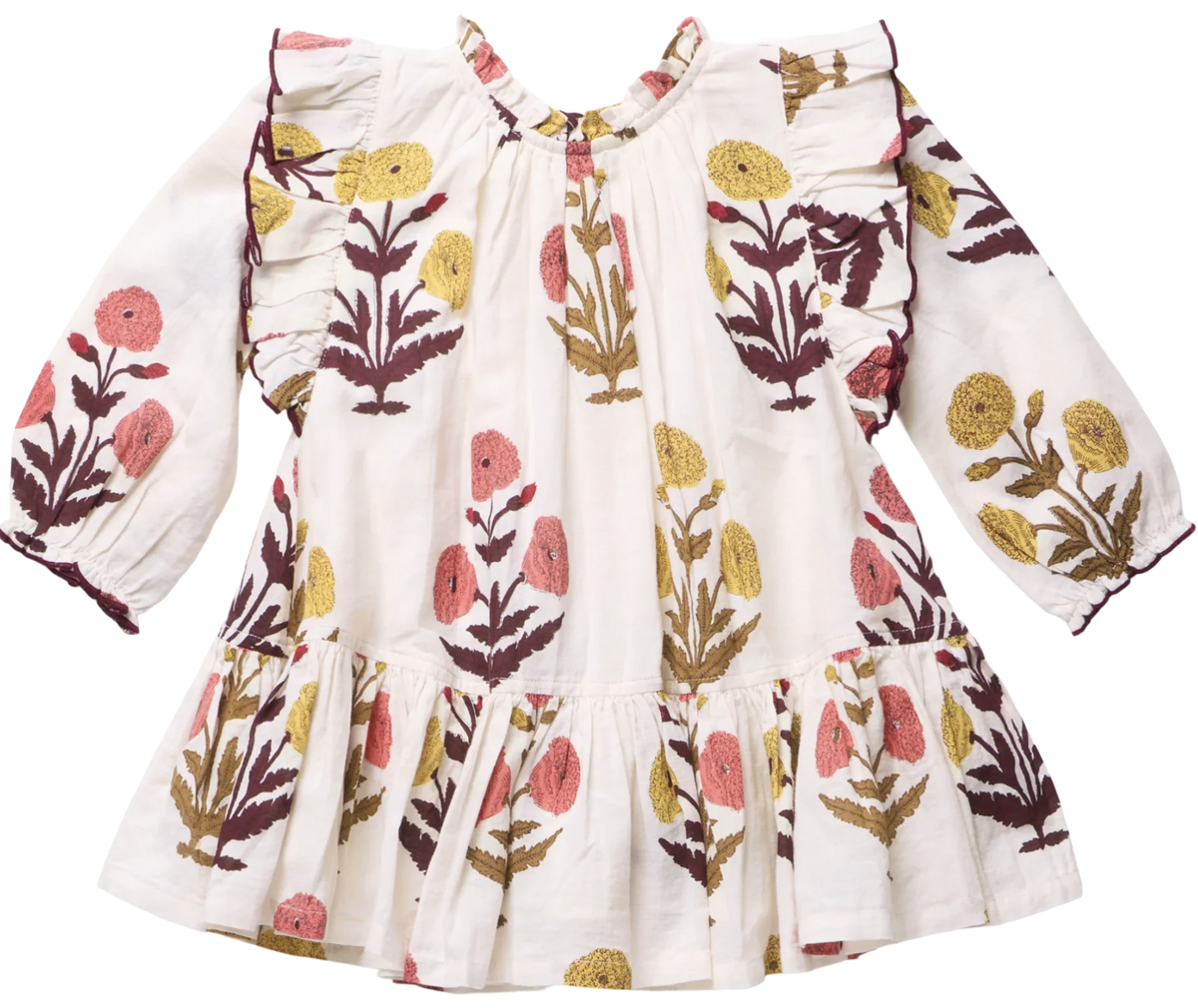 The Girls’ Harper Dress by Pink Chicken features a white long-sleeve design with a ruffled hem and Harvest Dandelion floral print in yellow, pink, and brown.