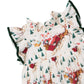 Pink Chicken Girls’ Jennifer Dress in cream featuring a Santa sleigh, evergreen tree, and house print with dark green velvet trim on the ruffle sleeves and neckline.