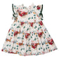 Pink Chicken Girls’ Jennifer sleeveless holiday dress with ruffled shoulders and a print of Santa in a sleigh, reindeer, and houses.