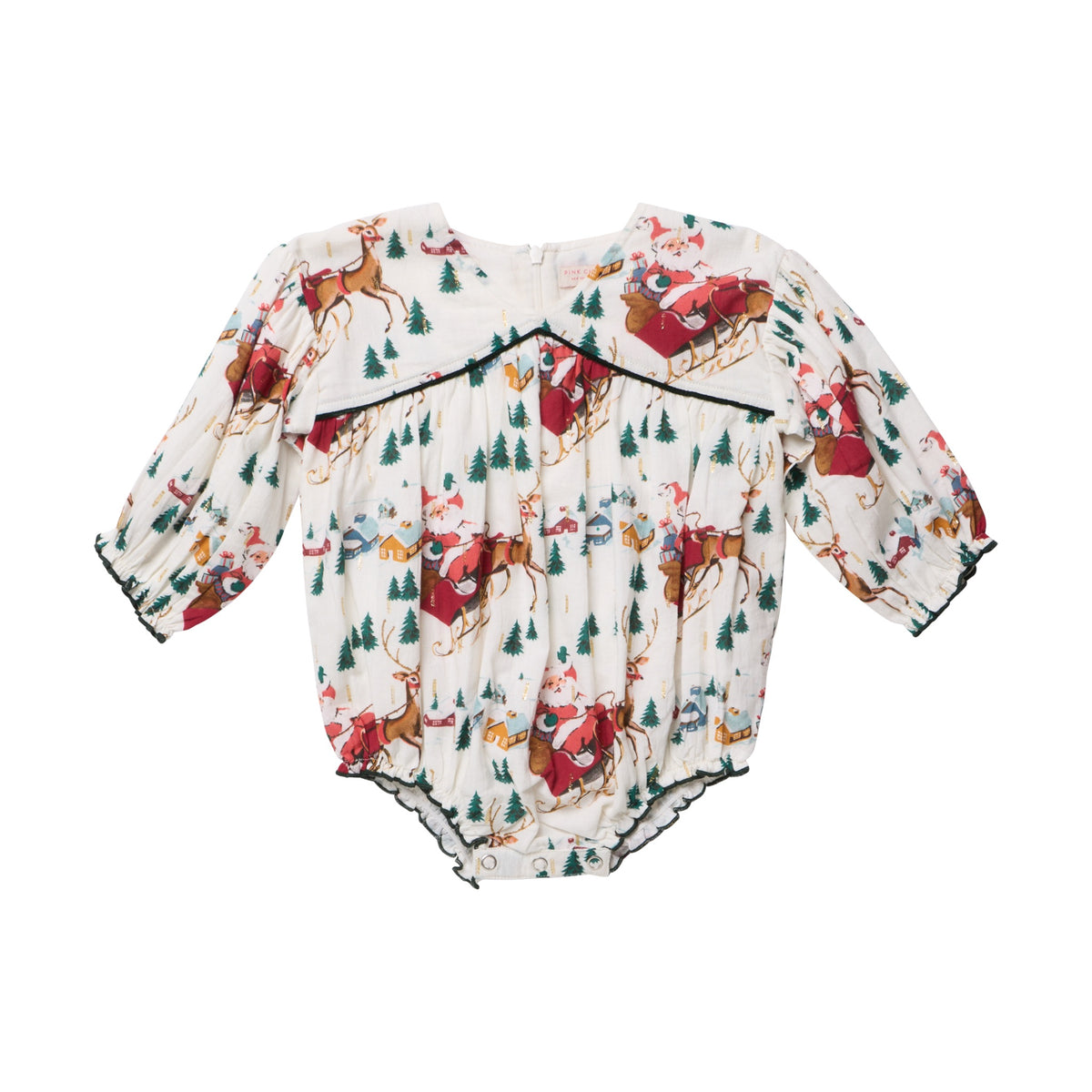 Pink Chicken Baby Girls’ Wynne Bubble long-sleeved holiday romper featuring a Santa sleigh print with reindeer, pine trees, and small houses, finished with dark green trim.