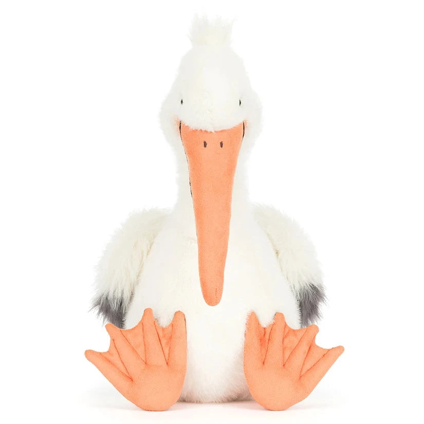 Jellycat's Keli Pelican plush toy, featuring white fur, an orange beak and feet, and gray wingtips, sits upright against a plain background—ready to host the next episode of "The Beak" talk show.