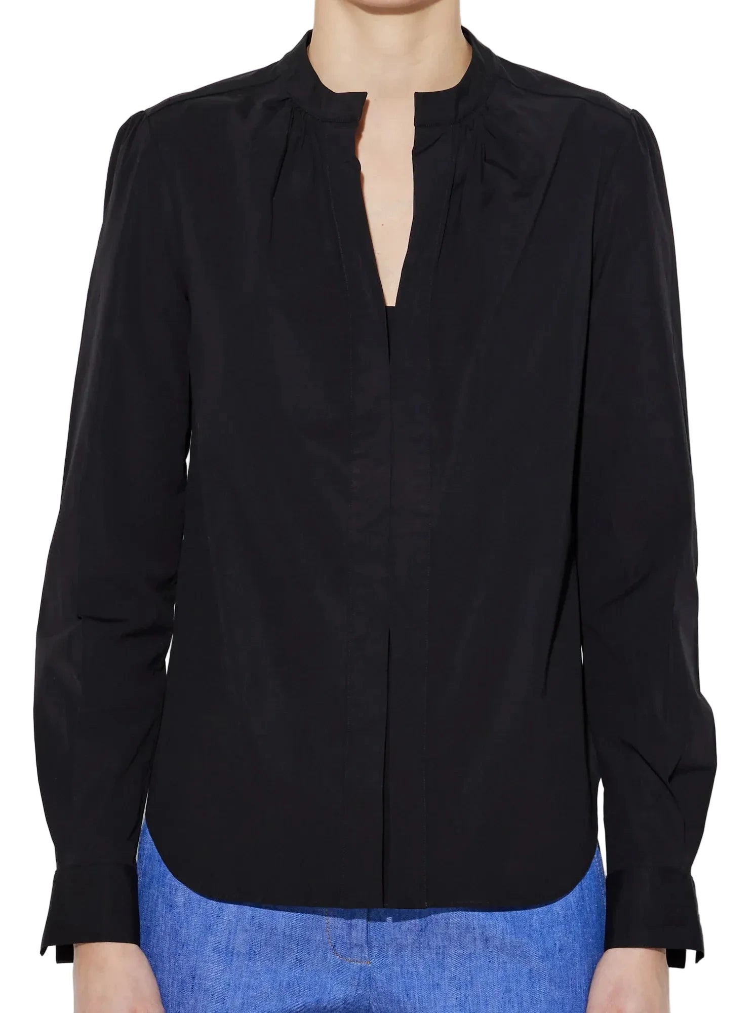 A person wears the Callas Milano Olympia Top, a black long-sleeved blouse with a collarless neckline, paired with blue pants and shown from the waist up.