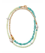 The Cabana Necklace by Lizzie Fortunato features turquoise stones, pale green and beige beads, gold accents, and two irregular pearls in a chic layered design.