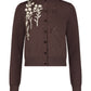 The Lela Rose Raffia Embroidered Knit Long Sleeve Cardigan features front buttons and white floral embroidery on soft brown knit.