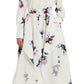 A woman wears the Erdem Long Sleeve Midi Shirt Dress, featuring a collared neckline, white cotton poplin fabric, and pink, blue, and purple rose bouquet floral prints.