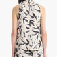 A woman is seen from behind wearing the Altuzarra Sleary Top, a sleeveless cream silk piece featuring a black bird and foliage print, paired with a matching skirt.