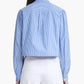 A person shown from the back wears the Altuzarra Margot Top—a blue and white vertically striped cotton-poplin shirt with balloon sleeves—paired with white high-waisted pants.