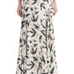 A person wearing the Altuzarra Elton Skirt—a cream, ankle-length skirt with a black bird print and flared silhouette—paired with open-toed black heels.