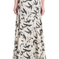 A person wearing the Altuzarra Elton Skirt, a long beige skirt featuring a black and gray abstract print and flared silhouette, is shown from the back against a white background.