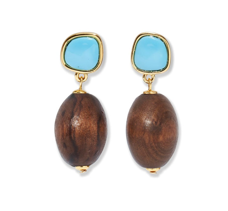 The Olea Earrings by Lizzie Fortunato feature irregular imitation turquoise stones atop large oval brown wooden beads, all gold-plated and shown against a white background.