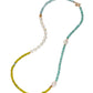 The Cabana Necklace by Lizzie Fortunato features single-strand sections of green, blue, and turquoise beads, white pearls, and a gold clasp—an iconic accessory inspired by the brand’s signature style.