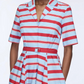 A person wears the Emilia Wickstead Mella Bayadere Stripe Dress, featuring red, white, and blue horizontal stripes, a V-neck collar, pockets, short sleeves, and a matching belt at the waist.