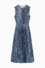 The Ulla Johnson Malin Satin Dress is a sleeveless, knee-length midi with a blue and black abstract pattern and a pleated skirt, shown on a white background.