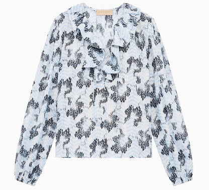 The Siena Top by Ulla Johnson is a light blue cotton-blend top with a black abstract pattern and ruffled collar, shown against a white background.