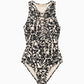 The Solina One Piece by Ulla Johnson is a sleeveless swimsuit showcasing a bold black and white leaf motif with sophisticated front lace-up detailing, presented against a plain white background.