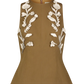 The Leather Floral Embroidered Rustic Top by Lela Rose is a sleeveless tan piece in stretch cotton, featuring a flared hem and white 3D floral appliqué for westernwear charm.