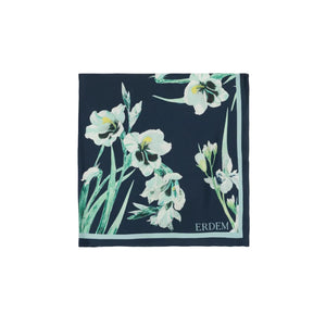The Erdem Floral Print Silk Twill Scarf features navy blue silk with white and green florals, "ERDEM" in one corner, and is a timeless accessory from the brand’s Pre Fall 2026 collection.