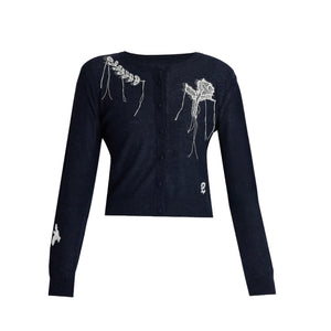 The Fine Alpaca Blend Fitted Cardigan by Erdem is a navy long-sleeve button-up featuring white embroidery on the shoulder, chest, sleeve, and hem, inspired by Erdem’s Belle Époque Pre Fall 2026 collection.