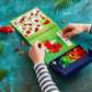 Using the Plus Plus Puzzle By Number® Activity Pad, a person assembles red, white, and orange pieces by following illustrated instructions in the spiral-bound activity pad on a blue-green tabletop—an engaging activity that sparks creativity and helps develop fine motor skills.