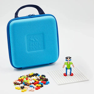 A Plus Plus Travel Case, base plate, small pixel-style figure, and colorful interlocking pieces are displayed on a white surface—ideal for creative play and STEM fun.