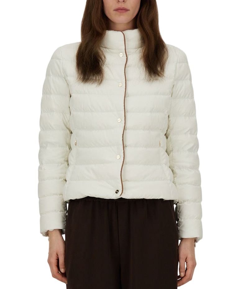 A person wears the Herno Arendelle Jacket—a white, quilted slim fit in super-matt polyester with brown trim—paired with dark pants, shown from the waist up.