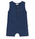The Cozmo Baby Boys' Pine Romper is a sleeveless, navy blue cotton gauze jumpsuit featuring three wooden buttons on the chest and two front pockets, displayed against a plain white background.
