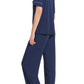 A person wearing a dark blue Eberjey Gisele Short Sleeve Long Pant PJ Set with piping details, crafted from sustainable TENCEL™ Modal, is standing with their back and side to the camera.