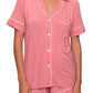 A person wearing the Eberjey Gisele Relaxed Short PJ Set, featuring a pink short-sleeve button-up top with white piping and matching shorts for a comfortable fit.