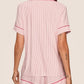 A person in the Eberjey Gisele Printed Stripe Relaxed Short PJ Set, featuring pink and white stripes with red trim, is shown from the back against a plain background. Made from buttery soft materials for ultimate comfort.