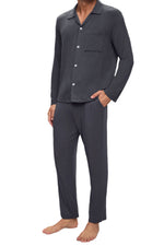 A person standing barefoot, dressed in the Eberjey Willam Ribbed Long PJ Set, which includes a breathable TENCEL™ Modal dark gray button-up long-sleeve top and matching pants with an elastic waistband.