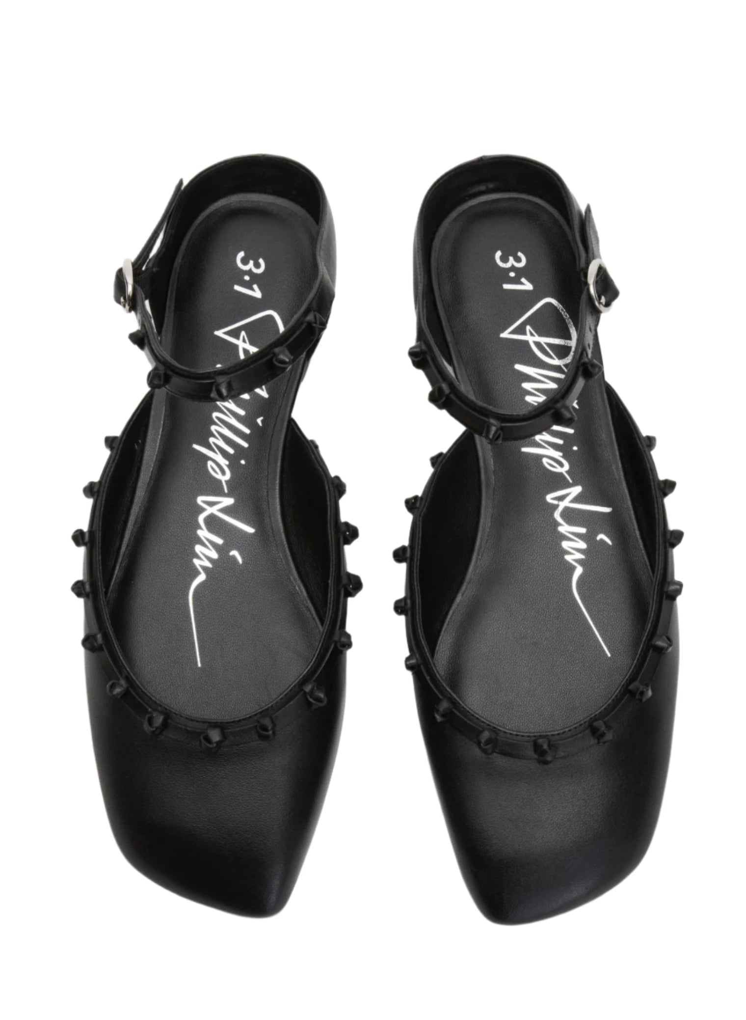 The 3.1 Phillip Lim ID Mary Jane Flat Leather Craft features a pair of black leather flat shoes with ankle straps and small decorative knobs around the edges. Its sculpted toe design enhances the elegant aesthetic, with an insole signature by 3.1 Phillip Lim.