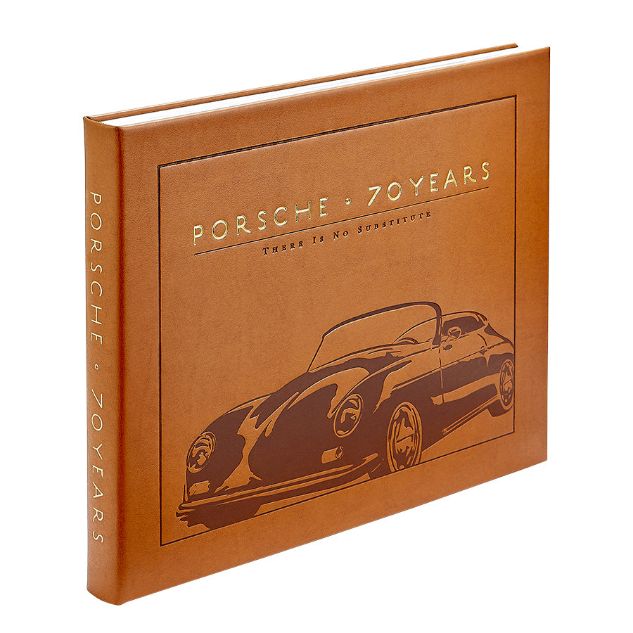 A brown hardcover book, “Porsche 70 Years: There is No Substitute” by Graphic Image, features an embossed Porsche outline and celebrates the brand’s rich automotive history.