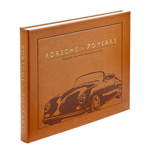 A brown hardcover book, “Porsche 70 Years: There is No Substitute” by Graphic Image, features an embossed Porsche outline and celebrates the brand’s rich automotive history.