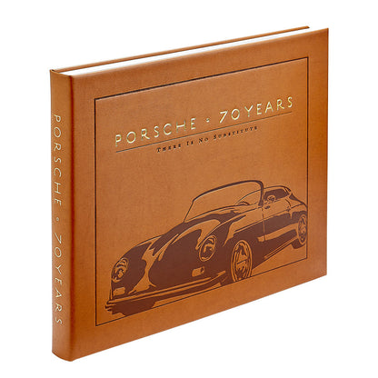 A brown hardcover book, “Porsche 70 Years: There is No Substitute” by Graphic Image, features an embossed Porsche outline and celebrates the brand’s rich automotive history.