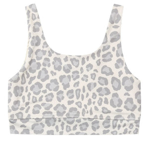 Rylee & Cru Girls’ Swift Sports Bra features a classic fit with a white scoop neck and light gray leopard print pattern, shown laid flat against a white background—perfect for everyday wear.