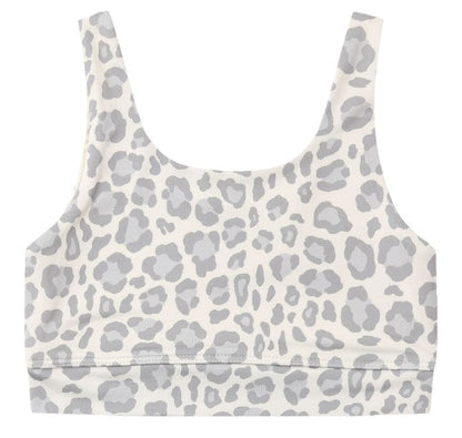 Rylee & Cru Girls’ Swift Sports Bra features a classic fit with a white scoop neck and light gray leopard print pattern, shown laid flat against a white background—perfect for everyday wear.