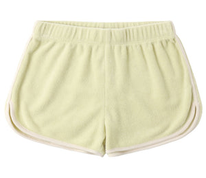 The Girls' Track Short by Rylee & Cru is a light yellow terry cloth short with an elastic waistband and white trim, shown flat with the back up—ideal summer shorts for relaxed comfort.