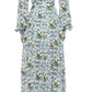 A person in the Prabal Gurung Huma Maxi Dress—a long-sleeved, ankle-length blue and white floral dress—seen from the back with white shoes. The flowy design brings movement and elegance to this chic look.