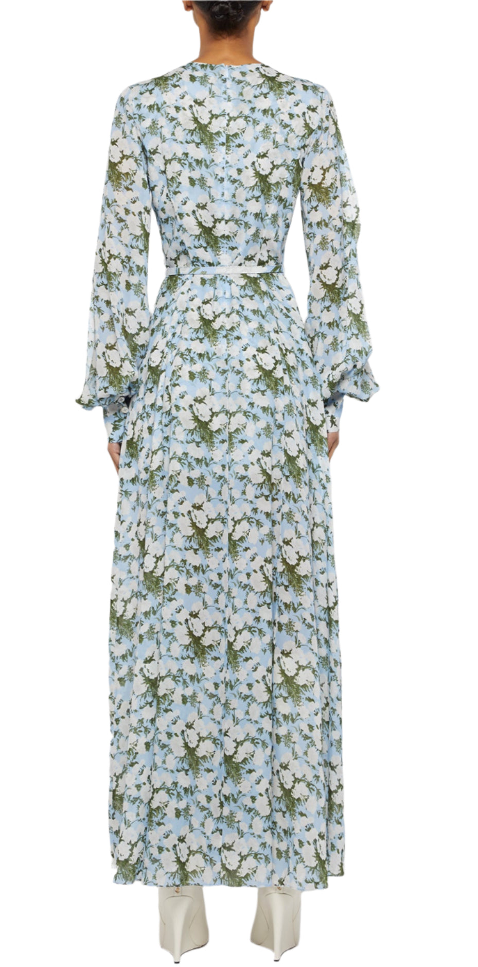 A person in the Prabal Gurung Huma Maxi Dress—a long-sleeved, ankle-length blue and white floral dress—seen from the back with white shoes. The flowy design brings movement and elegance to this chic look.