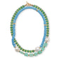 The Cabana Necklace by Lizzie Fortunato is a striking two-strand piece with alternating blue and green semiprecious beads, enhanced by gold accents and large pearl-like beads, offering a vibrant touch to any collection.
