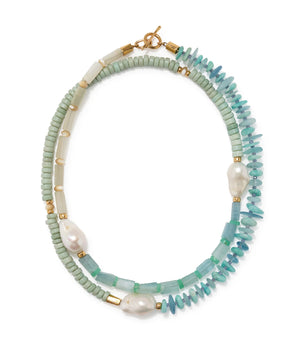 The Cabana Necklace by Lizzie Fortunato features double strands with light green and turquoise beads, irregular white pearls, gold accents, and a gold clasp.