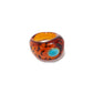 The Monument Ring by Lizzie Fortunato is a chunky amber-colored resin ring with dark spots and an oval turquoise stone on one side, shown against a white background.
