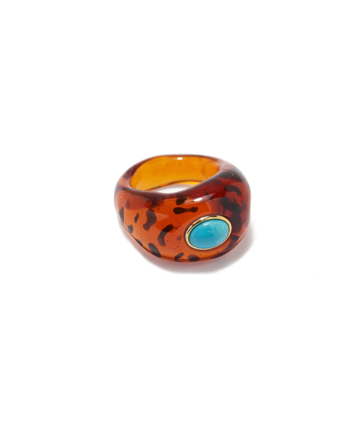 The Monument Ring by Lizzie Fortunato is a chunky amber-colored resin ring with dark spots and an oval turquoise stone on one side, shown against a white background.