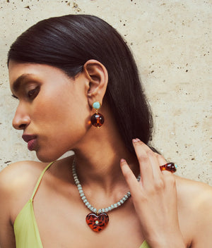 A woman wearing the Lizzie Fortunato Monument Ring, along with a necklace and earrings, creates an elegant look of wearable art.