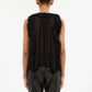 A model is shown from the back wearing the Ulla Johnson Sabra Cascading Ruffle Top—a sleeveless, sheer black pleated top with subtle ruffles—paired with black leather pants against a plain white background.