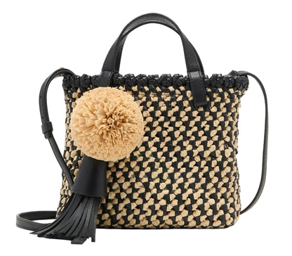 The Ulla Johnson Raffia Mini Crossbody is a chic hand-woven tote crafted from straw and black leather, featuring two handles, a shoulder strap, and playful tassel and pom-pom accents.