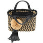 The Ulla Johnson Raffia Mini Crossbody is a hand-woven handbag featuring black and beige materials, black leather handles, a large beige pom-pom, and a black leather tassel—perfect as a chic mini tote for any occasion.