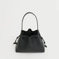 The Mansur Gavriel Drawstring Pouchette is a black Italian leather bucket bag with two handles and a drawstring closure, ideal for essentials. Shown against a plain white background.