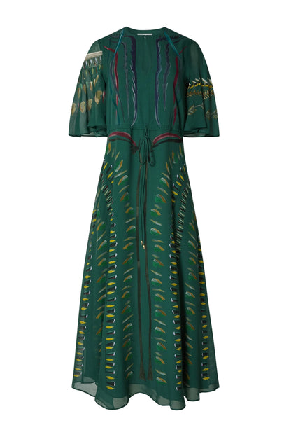 The Thessaly Dress by Altuzarra is a long, green silk dress with short sleeves and a tie waist, featuring an elegant leaf-patterned design in yellow, blue, and brown tones on the front and sleeves—an exquisite piece inspired by classic Italian style.